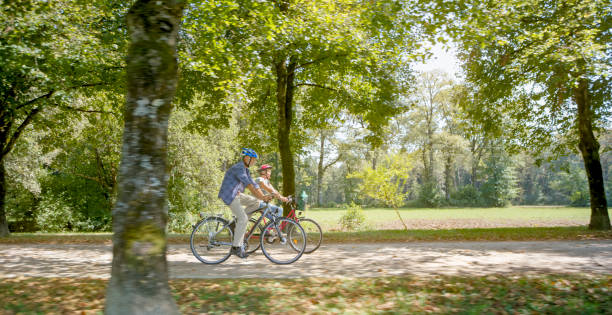 istock Family riding bicycle in park 973258844