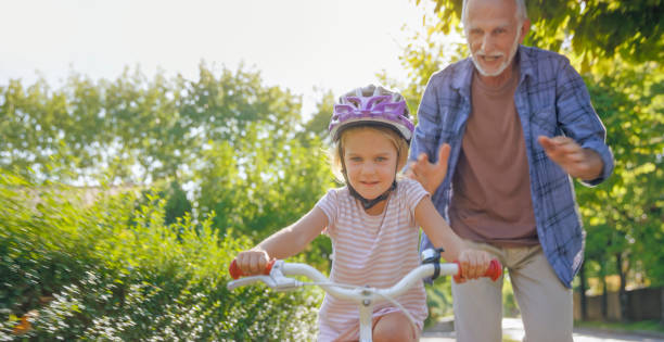 istock Senior man helping his granddaughter 973258872