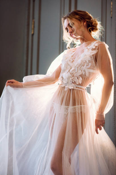 istock Beautiful lady in elegant white robe 973262136