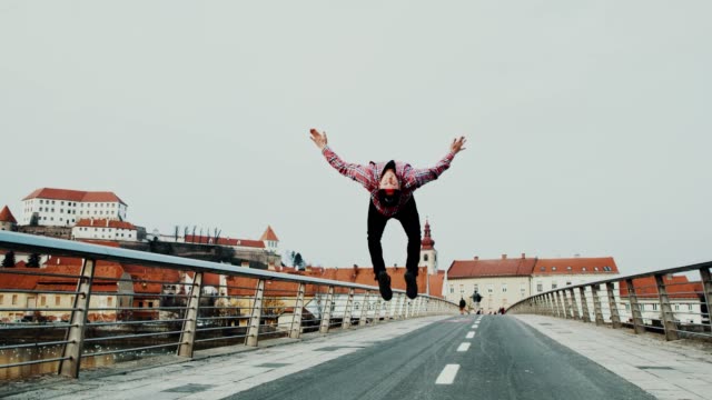 SLO MO Acrobatic breakdancer performing somersaults on the bridge