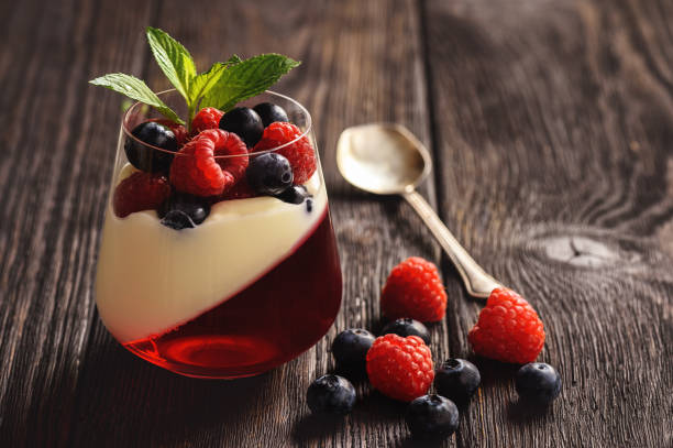 istock Pannacotta with berry jelly and berries on dark background. 973270060