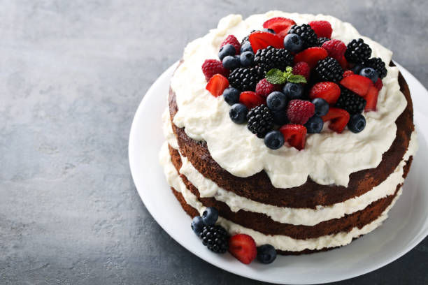 istock Delicious chocolate biscuit cake with berries on grey wooden table 973270222