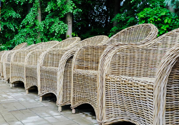 wicker chairs in a row in the park.