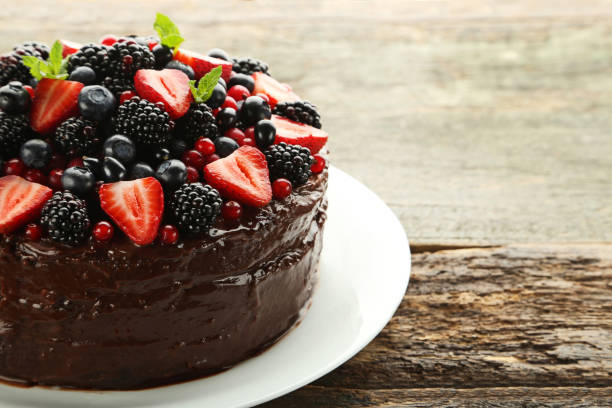 istock Chocolate cake with berries in plate on wooden table 973271632