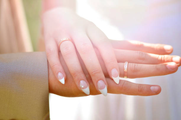 istock Hands with the wedding rings at sunset. 973273994