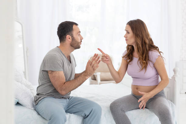 Irritated man and pregnant woman contending