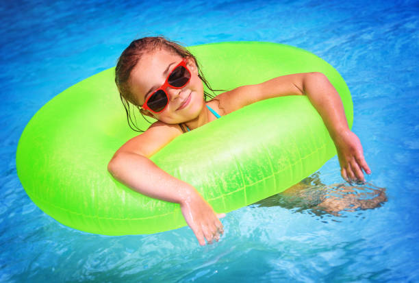istock Cute little girl in the pool 973279024