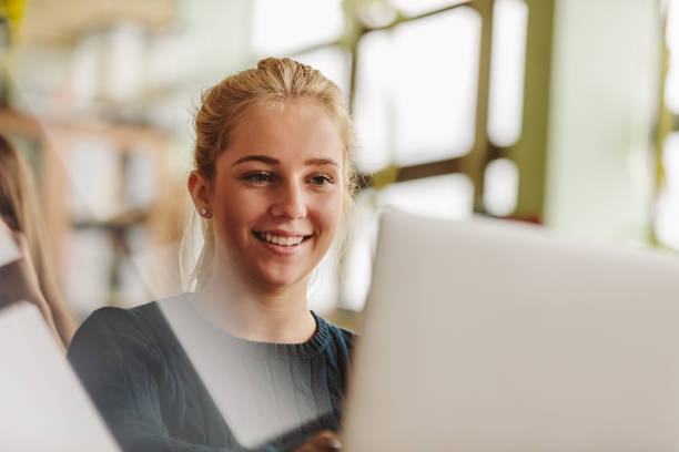 ragazza che studia con il laptop in classe universitaria - teenage girls women female caucasian foto e immagini stock