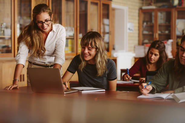 istock Teacher helping her student at high school 973280390