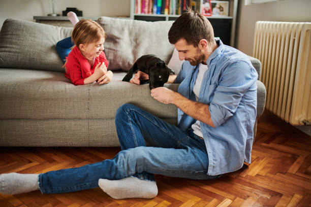 istock Father with child and black puppy 973283948