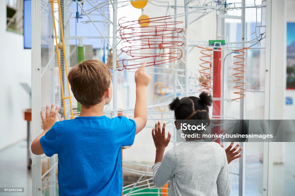 Two kids looking at a science exhibit,  back view Museum Stock Photo