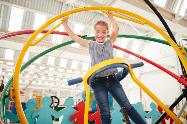 Young white girl having fun using a human gyroscope