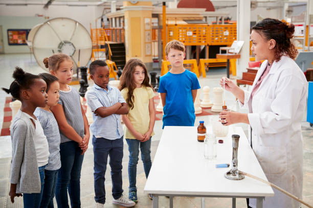 istock Lab technician with group of kids carrying out an experiment 973293324