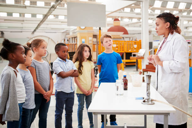 istock Lab technician carrying out experiment for a group of kids 973293334