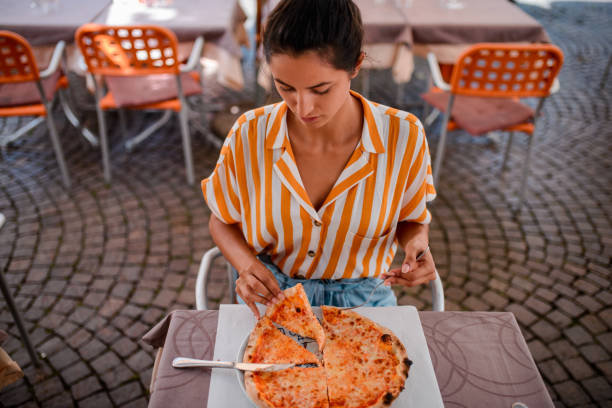 istock Tourist woman eating pizza. 973294054
