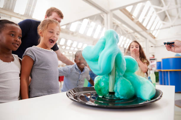 Group of kids and teachers carrying out a science experiment Group of kids and teachers carrying out a science experiment chemical reaction stock pictures, royalty-free photos & images