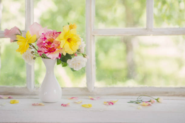 istock roses oin vase on old windowsill 973297136