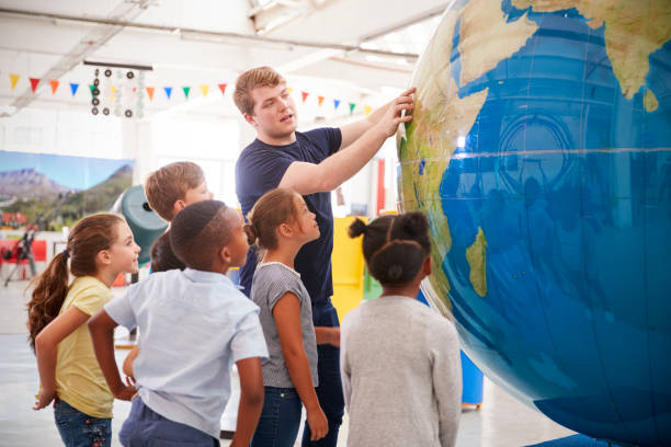 enfants regardent la présentation avec un globe géant dans un centre de sciences - géographie physique photos et images de collection