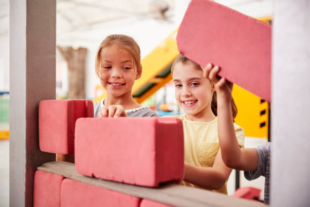 Schoolgirls building with toy bricks, close up