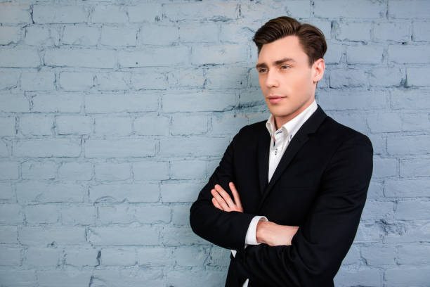 istock Serious minded man in black suit with crossed hands 973297614