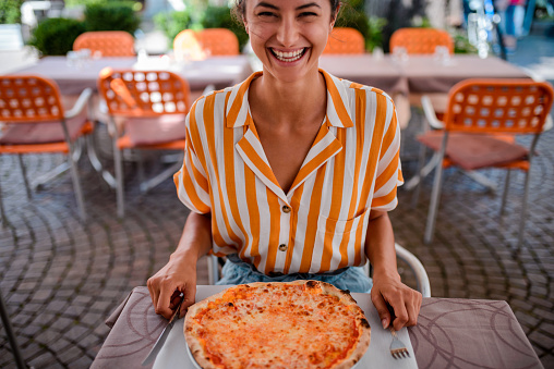 High angle view of a tourist woman eating pizza in Italy