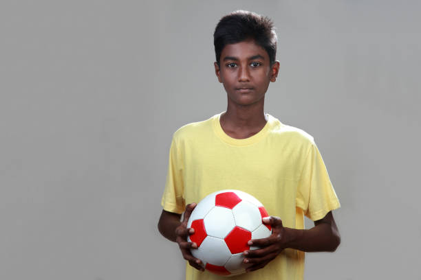 istock Young boy holding a soccer ball in his hand 973300516