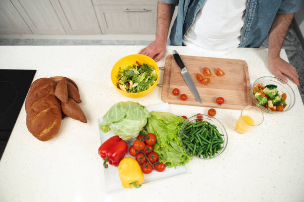 istock Fresh vegetables near guy in kitchen 973301296