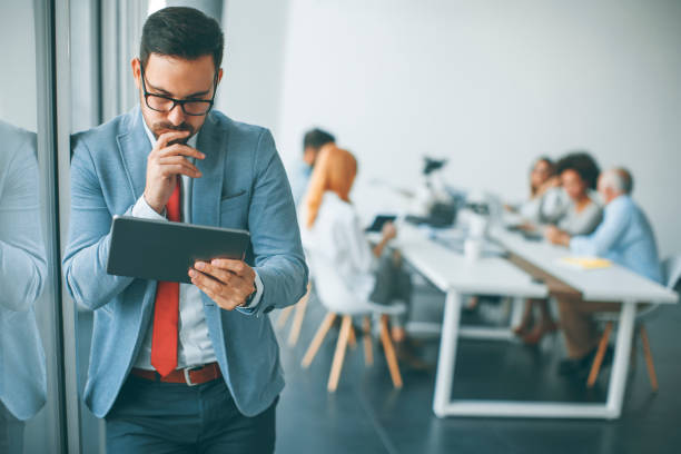 istock Young businessman with digital tablet in office 973301348