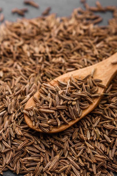 istock Seeds of cumin on a dark stone background 973311242