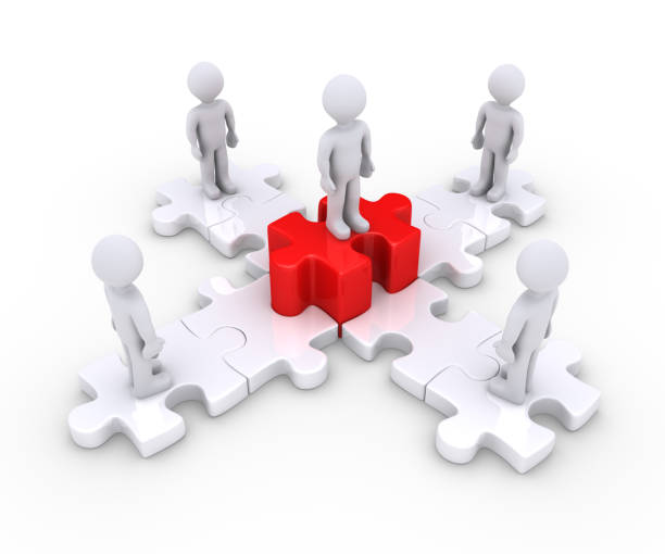 istock People on puzzle pieces and a leader 973313488