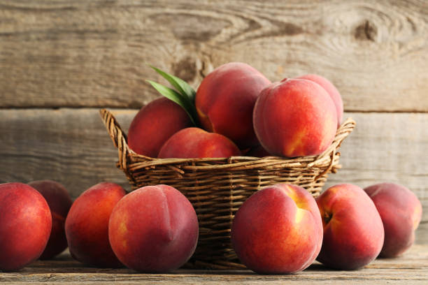 istock Sweet nectarines in basket on grey wooden table 973318424