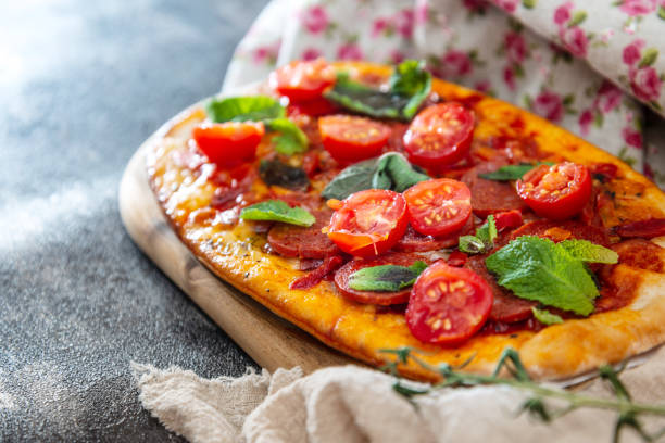 istock Sausage Pizza with Ham and tomatoes 973318706