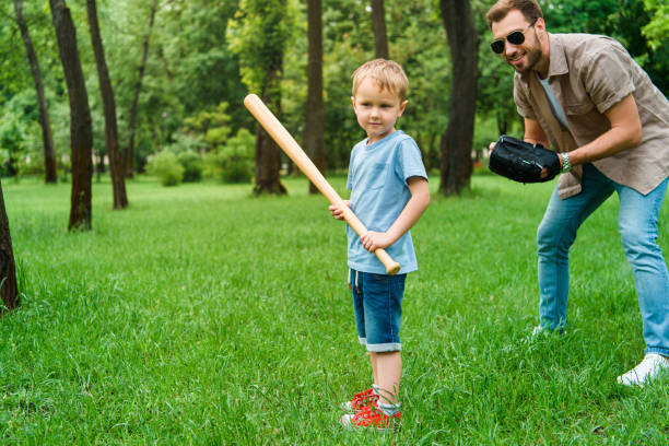 istock father and son playing baseball together at park 973318932