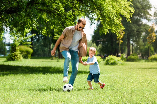 お父さんと息子の公園でサッカー - ball horizontal outdoors childhood ストックフォトと画像