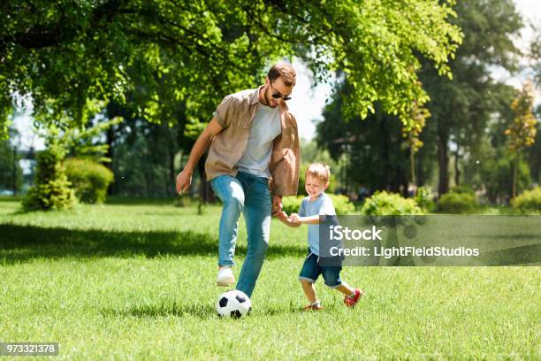 Dad And Son Playing Football At Park Stock Photo - Download Image Now - Family, Father, Public Park