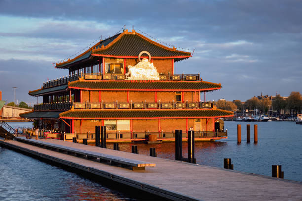 AMSTERDAM, NETHERLANDS - MAY 9, 2017: Sea Palace chinese pagoda styled restaurant on sunset. It is the first floating restaurant in Europe