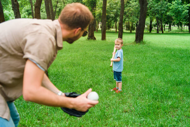 istock father and son playing baseball at park 973325980