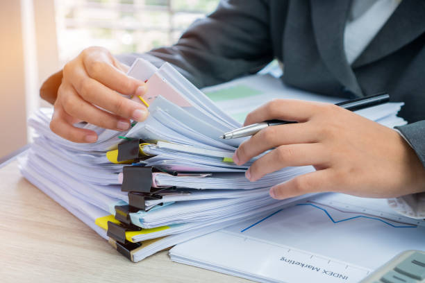 istock Hands young female business managers checking and arranging stack of unfinished documents reports papers for result graph marketing, startup project for plan job succes in Busy office with flare light 973328830