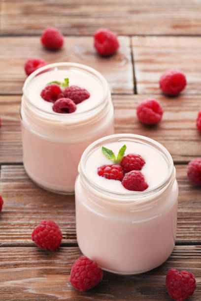 istock Raspberries yogurt in jars on brown wooden table 973333964