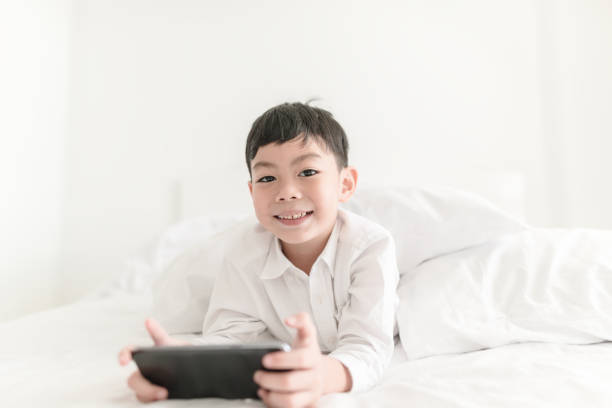 istock Kid with smartphone in the bedroom indoor. 973338518