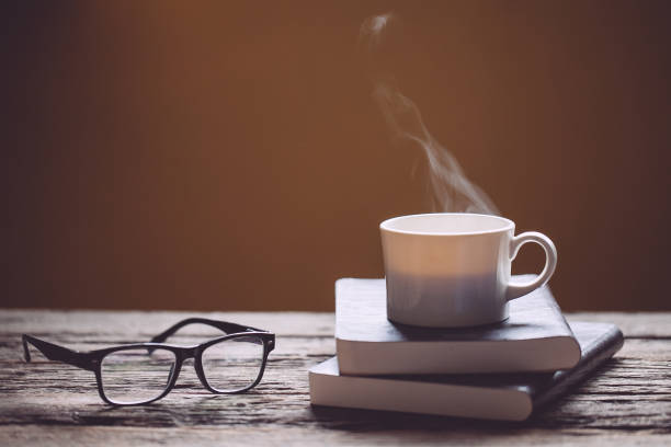 istock cup of coffee on book and wooden table 973342332