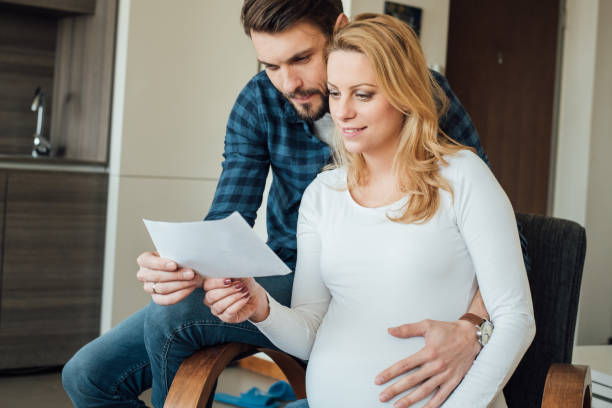 istock Husband hugging pregnant wife while looking at ultrasound scan 973342334
