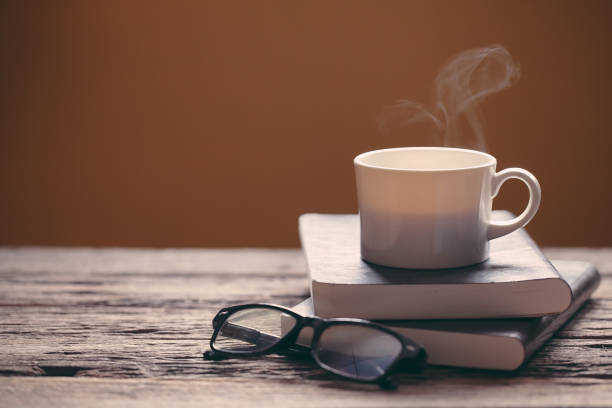 istock cup of coffee on book and wooden table 973342484