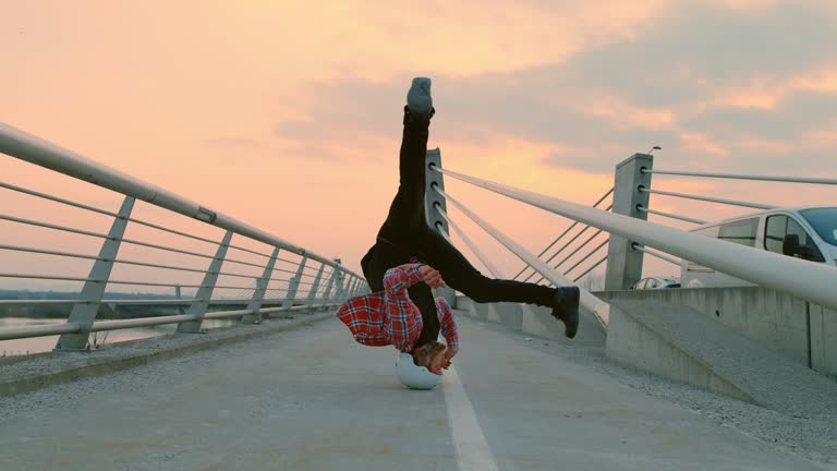SLO MO B-boy spinning on his head on the bridge