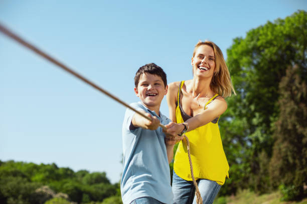 istock Joyful family pulling a rope in the park 973347614