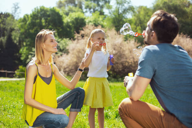 istock Loving parents blowing bubbles with their daughter 973347722