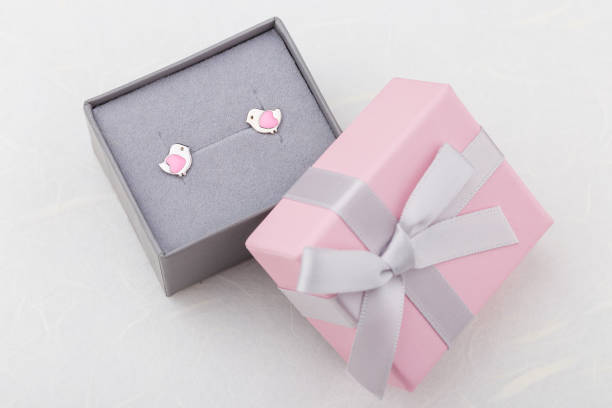 istock Bird shape with hearts earring studs in pink gift box on white background 973367192