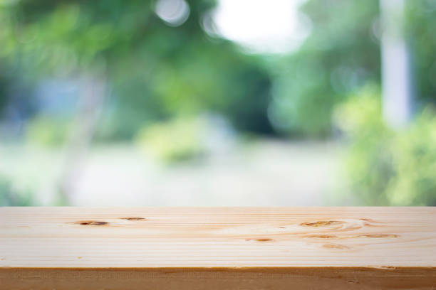 istock empty wooden on blurred nature backdrop. Wood table top. can used for display or montage your products 973367740
