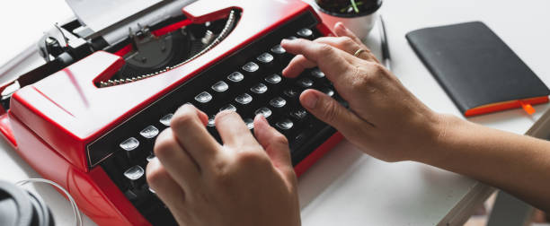 istock Woman hand working with bright red vintage typewriter 973371262