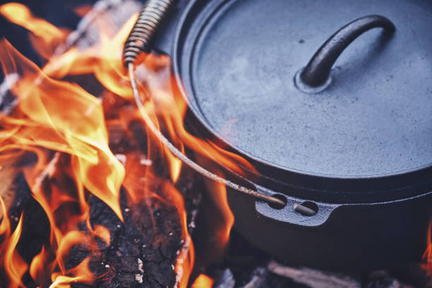istock Cooking Chili Con Carne in Dutch Oven over Logfire 973374862
